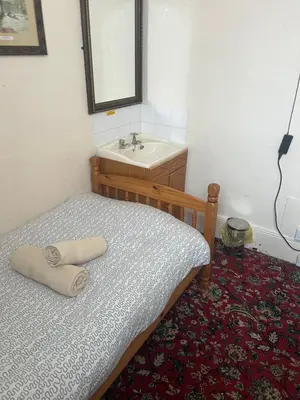 a bedroom with a bed and a sink and a mirror at Apollo Number 7 in Blackpool