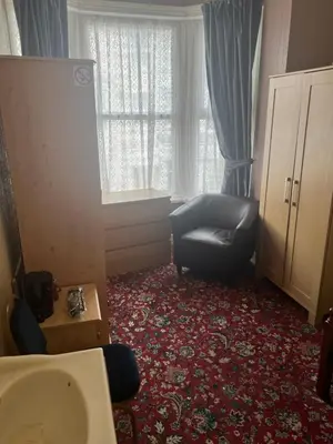 a bathroom with a chair and a sink and a window at Apollo Number 7 in Blackpool