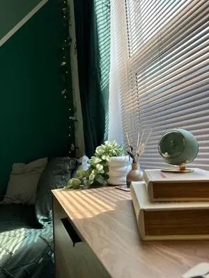 a table with books and flowers on it next to a window at Winter Gardens Flat 2 - Studio The Retreat in Blackpool