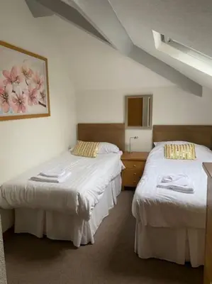 a room with two beds and a dresser in it at Garnett - Comfy apartment, great location! in Clitheroe