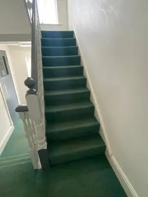 a stairway with blue and green stairs in a building at Garnett - Comfy apartment, great location! in Clitheroe