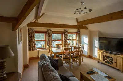 a living room with a couch and a dining room at Garnett - Comfy apartment, great location! in Clitheroe