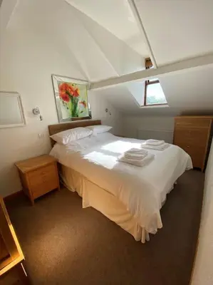 a bedroom with a large white bed with a window at Garnett - Comfy apartment, great location! in Clitheroe