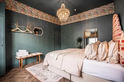 a bedroom with a large bed and a chandelier at Arkles - Victorian Gem in Liverpool
