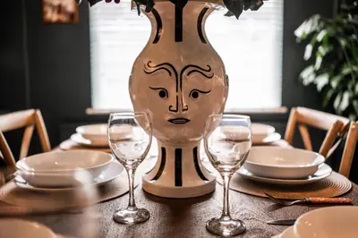 a table with glasses and a vase with a face on it at Arkles - Victorian Gem in Liverpool