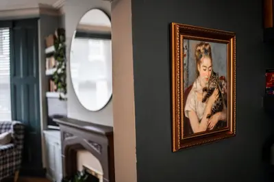 a painting of a woman on a wall with a mirror at Arkles - Victorian Gem in Liverpool
