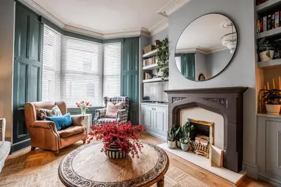 a living room with a fireplace and a mirror at Arkles - Victorian Gem in Liverpool