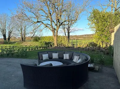 a couch sitting in the middle of a yard at Lovely country cottage in Dalton / Parbold in Wigan