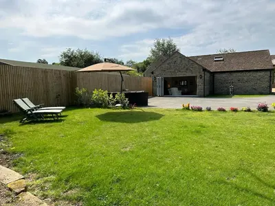 a yard with a bench and an umbrella at Lovely country cottage in Dalton / Parbold in Wigan