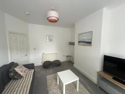 a living room with a couch and a tv and a table at New Flat in Lytham St Annes - Sleeps 4 in Saint Annes on the Sea
