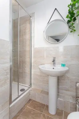 a bathroom with a sink and a shower and a mirror at Edge Grove Retreat - Air Host & Stay in Liverpool