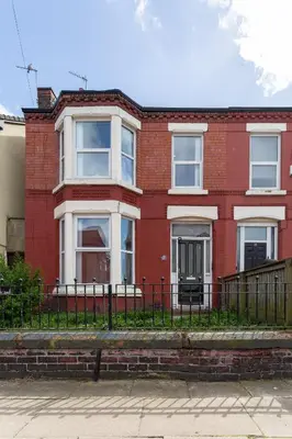 a red brick house with a black fence at Edge Grove Retreat - Air Host & Stay in Liverpool