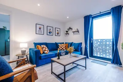 a living room with a blue couch and a table at NEW! Pristine 2-Bed Flat on Liverpool by 53 Degrees Property, Amazing Location, Sleeps 6! in Liverpool