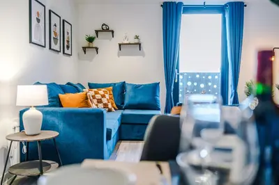 a living room with a blue couch and a window at NEW! Pristine 2-Bed Flat on Liverpool by 53 Degrees Property, Amazing Location, Sleeps 6! in Liverpool