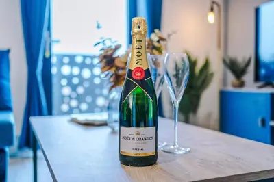 a bottle of wine sitting on a table with a glass at NEW! Pristine 2-Bed Flat on Liverpool by 53 Degrees Property, Amazing Location, Sleeps 6! in Liverpool