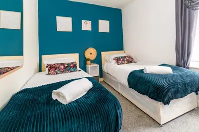 two beds in a room with blue walls at Liverpool City Haven-Dane Street in Liverpool