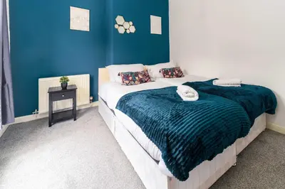 a bedroom with a bed with a blue wall at Liverpool City Haven-Dane Street in Liverpool