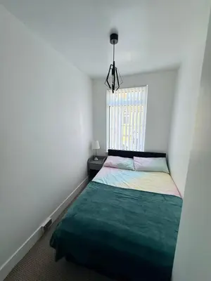 a small bedroom with a bed and a window at Cityscape-Cosy House By Anfield in Liverpool