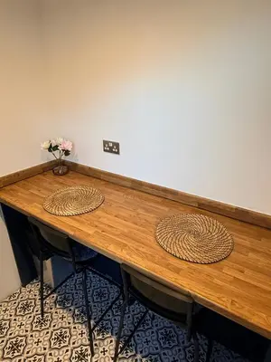 a wooden table with a vase of flowers on it at Cityscape-Cosy House By Anfield in Liverpool
