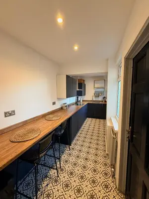 a kitchen with a wooden counter top in a room at Cityscape-Cosy House By Anfield in Liverpool