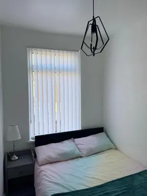 a bedroom with a bed in front of a window at Cityscape-Cosy House By Anfield in Liverpool