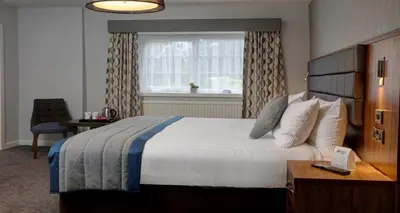 a hotel room with a large bed and a window at Best Western Plus Lancashire Manor Hotel in Skelmersdale