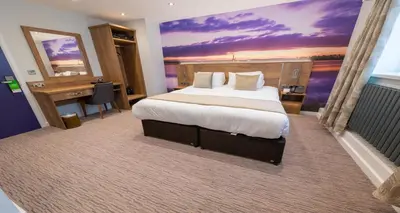 a hotel room with a large bed and a desk at Best Western Plus Lancashire Manor Hotel in Skelmersdale