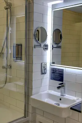 a bathroom with a sink and a shower and a mirror at Best Western Plus Lancashire Manor Hotel in Skelmersdale