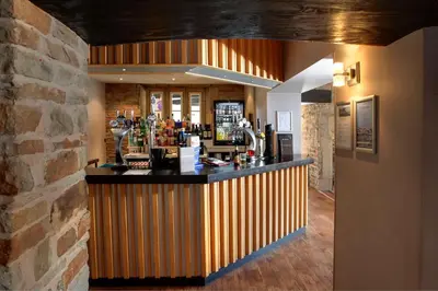 a bar in a restaurant with a brick wall at Best Western Plus Lancashire Manor Hotel in Skelmersdale