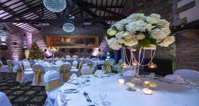 a banquet hall with white tables and chairs and flowers at Best Western Plus Lancashire Manor Hotel in Skelmersdale