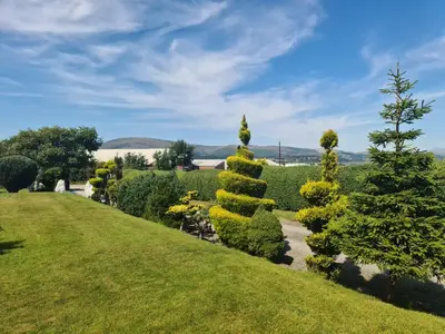a garden with bushes and trees on a lawn at Duddon Villa in Millom