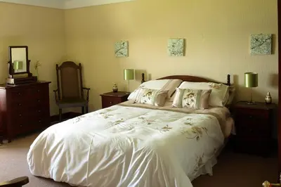 a bedroom with a large white bed and a mirror at Duddon Villa in Millom