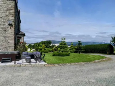 a patio with a table and chairs on a lawn at Duddon Villa in Millom