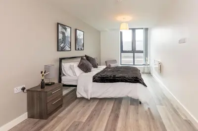 a bedroom with a large bed and a wooden floor at L1 Comfy Escapes - Long Stay Discounts Apply! in Liverpool