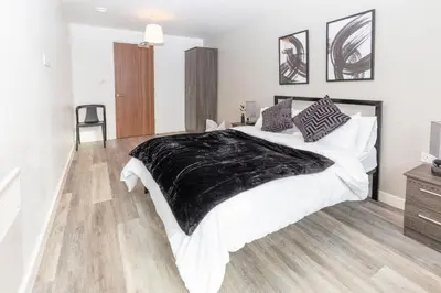 a bedroom with a large bed with a black blanket on it at L1 Comfy Escapes - Long Stay Discounts Apply! in Liverpool