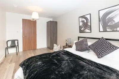 a bedroom with a bed with a black blanket on it at L1 Comfy Escapes - Long Stay Discounts Apply! in Liverpool