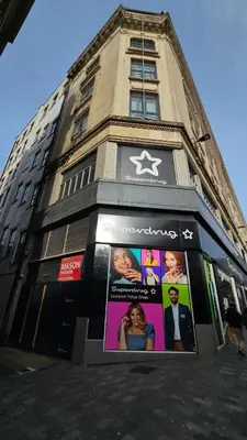 a tall building with posters on the side of it at L1 Comfy Escapes - Long Stay Discounts Apply! in Liverpool