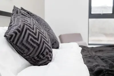 a white couch with two pillows on it at L1 Comfy Escapes - Long Stay Discounts Apply! in Liverpool