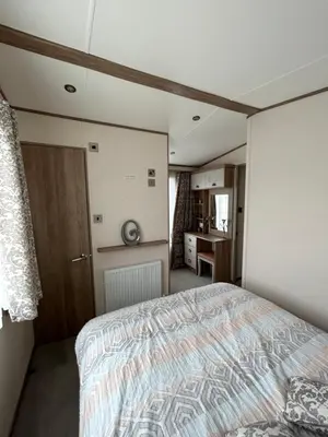 a bedroom with a large bed and a kitchen at Deck Of The Bay in Heysham