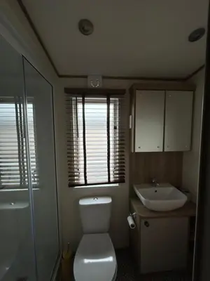 a small bathroom with a toilet and a sink at Deck Of The Bay in Heysham