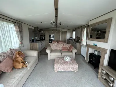 a living room with a dog laying on a couch at Deck Of The Bay in Heysham
