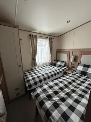 two beds in a small room with a window at Deck Of The Bay in Heysham