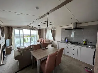 a kitchen and living room with a table and chairs at Deck Of The Bay in Heysham
