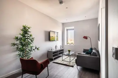 a living room with a couch and a plant at Modern & Spacious 2 Bed Apartment in Waterloo Liverpool in Waterloo