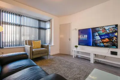 a living room with a couch and a large screen tv at Modern Home: Heart Of Blackburn in Blackburn