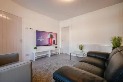 a living room with a couch and a flat screen tv at Modern Home: Heart Of Blackburn in Blackburn