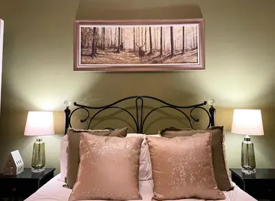 a bedroom with a bed with two lamps and a painting at Apartment 2 West County by Prestige Properties SA in Millom