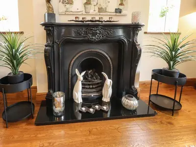 a fireplace in a living room with two plants at Linwood in Thornton