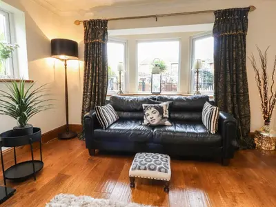 a black leather couch in a living room with windows at Linwood in Thornton
