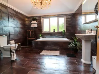 a bathroom with a large tub and a sink at Linwood in Thornton